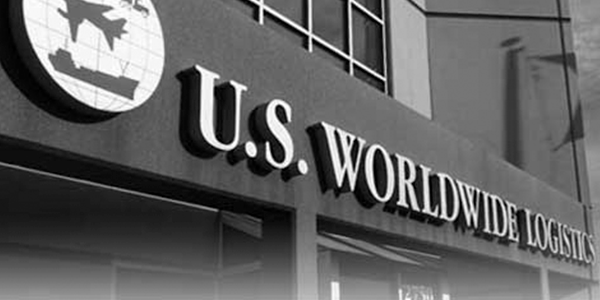 黑白照片中，建筑立面悬挂着标有"美国环球物流"字样的招牌，其地球仪标志上绘有飞机与货轮图案。