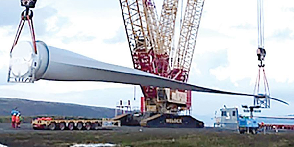 Giant rotor being lifted by crane.