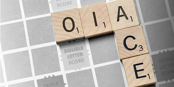 Scrabble tiles spelling “OIA” and “ACE” arranged on a game board, representing OIA Global’s acquisition of American Cargo Express.