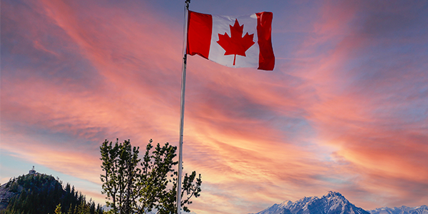 Canadian flag in colorful sky.