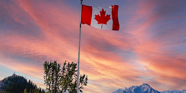 Bandera canadiense en cielo colorido.