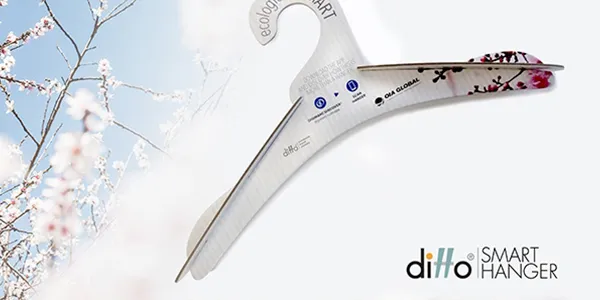 Percha ecológica Ditto Smart Hanger fabricada con materiales sostenibles con la marca impresa y un diseño floral, sobre un fondo claro.