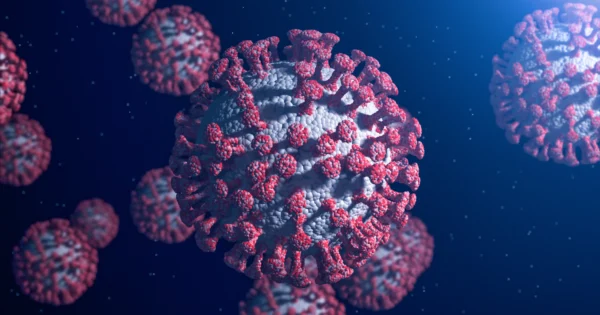 コロナウイルス（SARS-CoV-2）粒子の3Dレンダリング。紺色を背景に、灰色の球面上に赤いスパイクタンパク質を持つ。