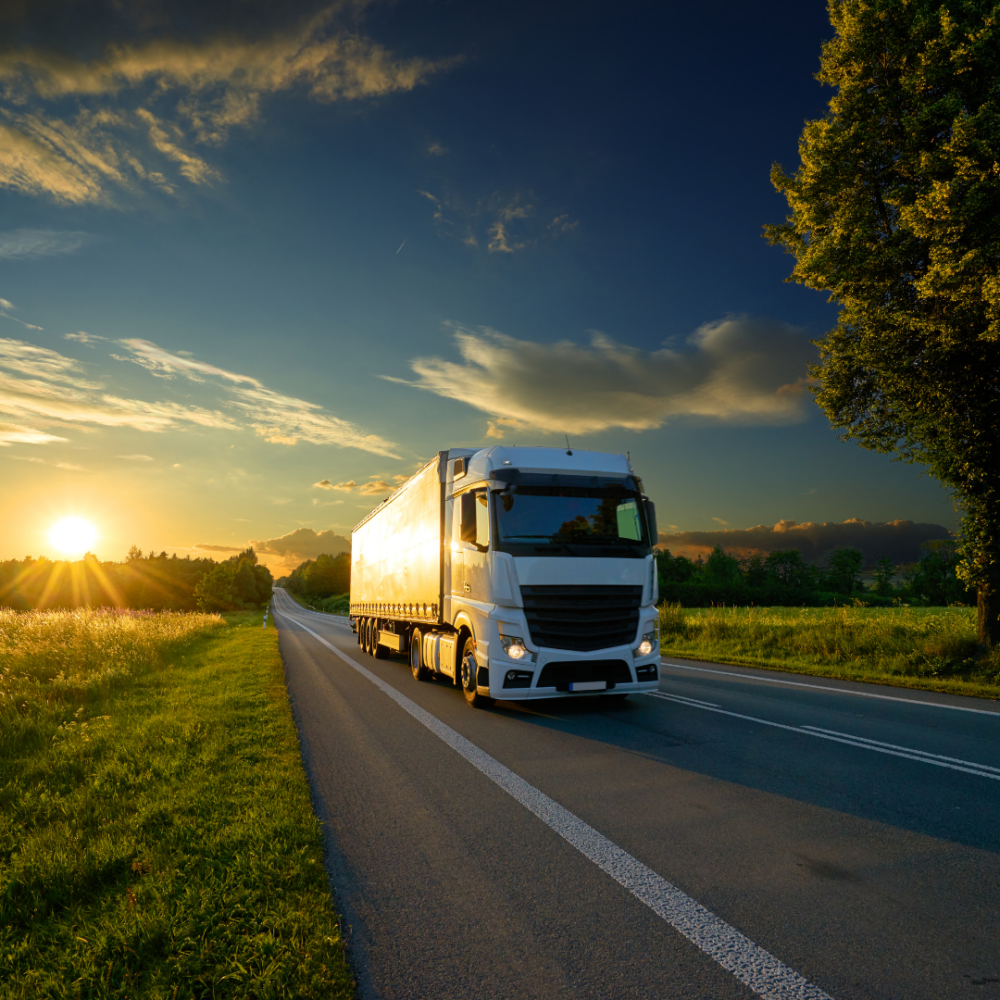 Freight truck localization showing semi driving toward camera during sunset in countryside.