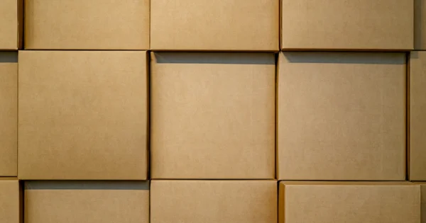 Stacked brown cardboard boxes arranged in a uniform grid pattern for efficient packaging and storage.