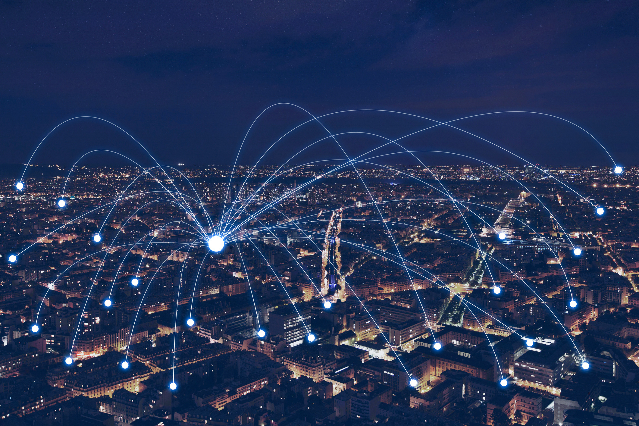 Horizonte nocturno de la ciudad con líneas y nodos de red resplandecientes que representan la conectividad digital global y el intercambio de datos.