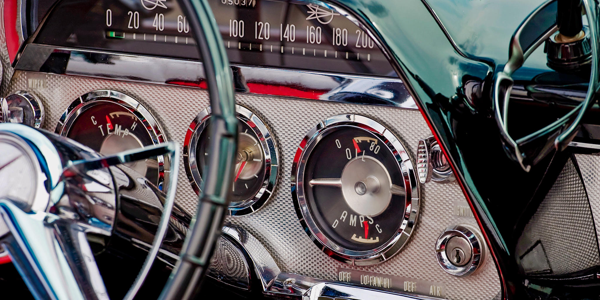 Close up of a classic car's steering wheel and dashboard