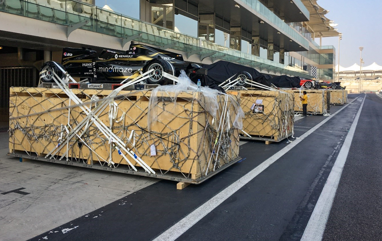 Automotive and mobility operations showing formula one F1 racecars above boxes before loading into plane.