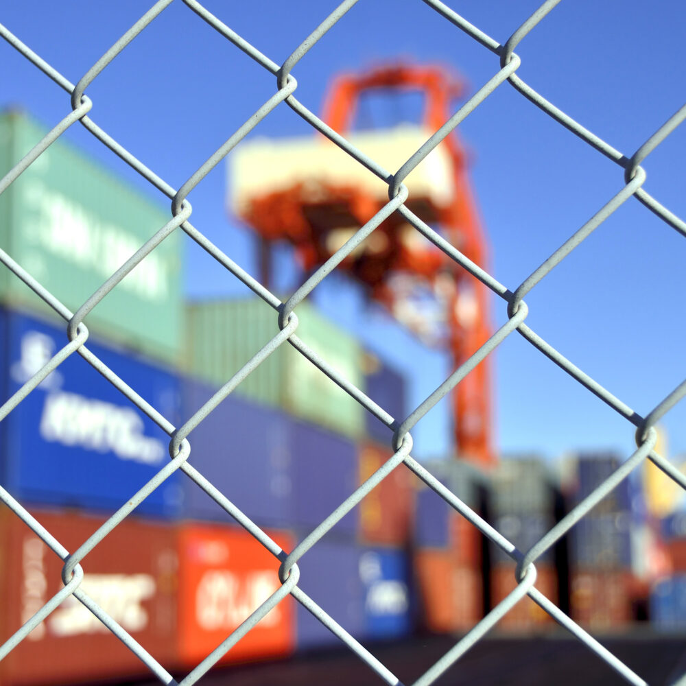 Ocean freight port operations customs compliance container yard security fence.