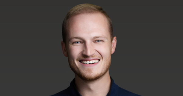 Professional portrait of OIA Global leadership team member in a navy zip-up jacket