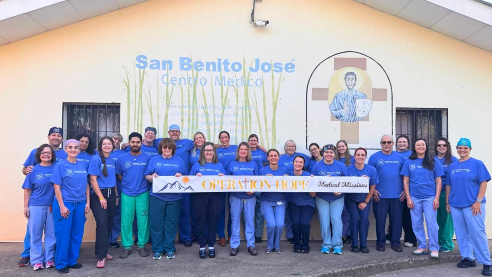 Group of medical volunteers holding an Operation Hope banner outside San Benito José Centro Médico.